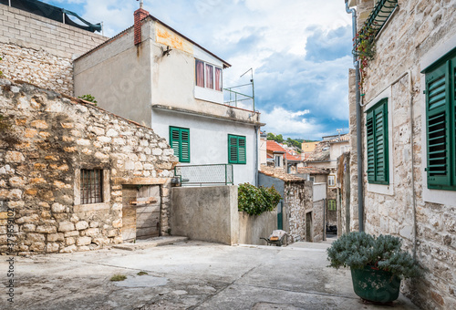 Old narrow street on a hill with sandstone houses in Sibenik town, Croatia