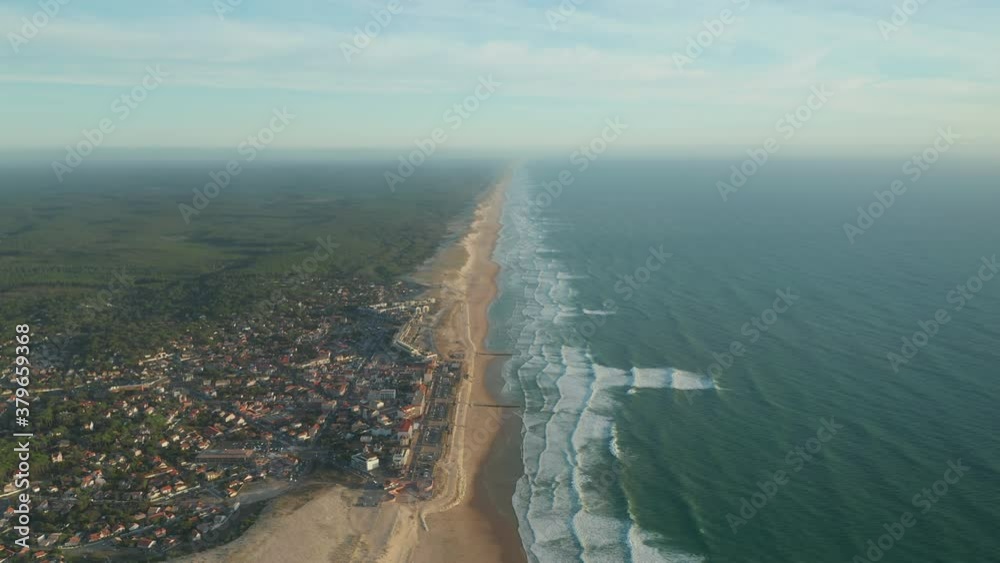 Small Beach Town Village Lacanau in France at Sunset, Aerial Establishing Wide Shot forward with Endless Shore Line in distance