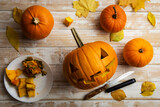Halloween carving. Close up of pumpkins or jack-o-lantern and knife at home. Decoration and holidays concept