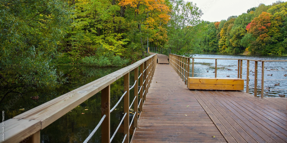 Bridge and walking wooden path over the lake on an autumn morning Bridge and walking wooden path over the lake on an autumn morning