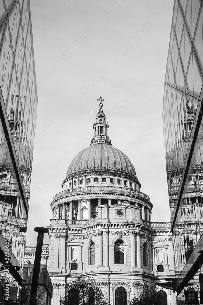 Black and white photo of Saint Paul Cathedral reflected in modern glass walls in City of London, England