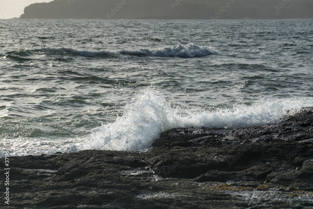 Panoramic view of sea waves crashing on rocks at Velneshwar beach in India Panoramic view of sea waves crashing on rocks at Velneshwar beach in India