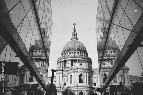 Black and white photo of Saint Paul Cathedral reflected in modern glass walls in City of London, England