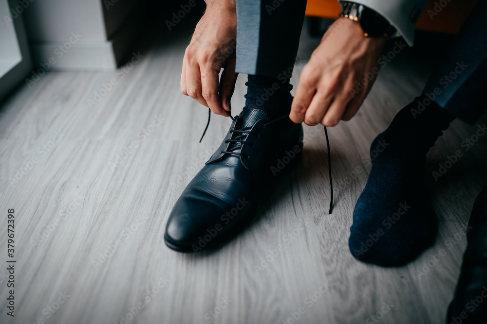 Anziehen von einem Schuh während einer Vorbereitung bei einer Hochzeit Anziehen von einem Schuh während einer Vorbereitung bei einer Hochzeit