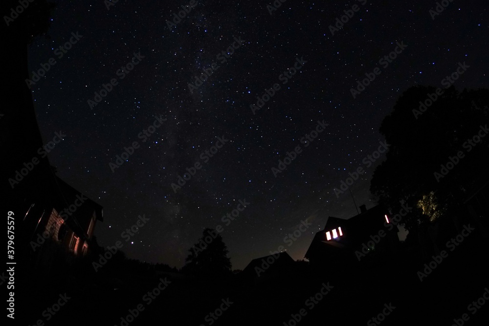Fototapeta premium Blue dark night sky with many stars. Night sky over rural landscape. high ISO landscape with fisheye lens