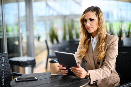 Young businesswoman on a coffee break. Using tablet computer. Free Download Young businesswoman on a coffee break. Using tablet computer. - GFXLoad