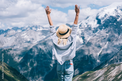 Slim lady with raised arms in mountains