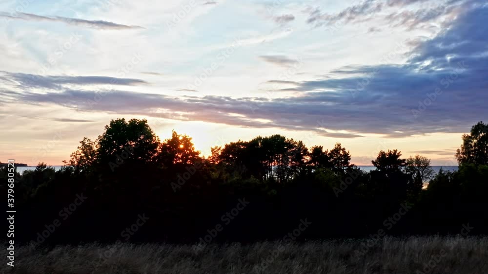 Aerial of a beautiful sunset shine through trees by the sea Aerial of a beautiful sunset shine through trees by the sea