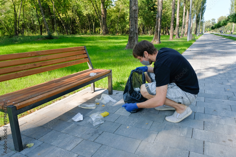Fototapeta premium A volunteer removes rubbish in public parks. Pollution of nature, environmental problems. Environmental protection concept