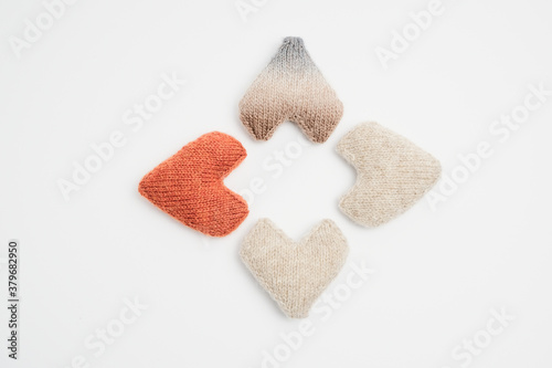 4 knitted hearts folded in a rhombus on a white background © Ozzyki
