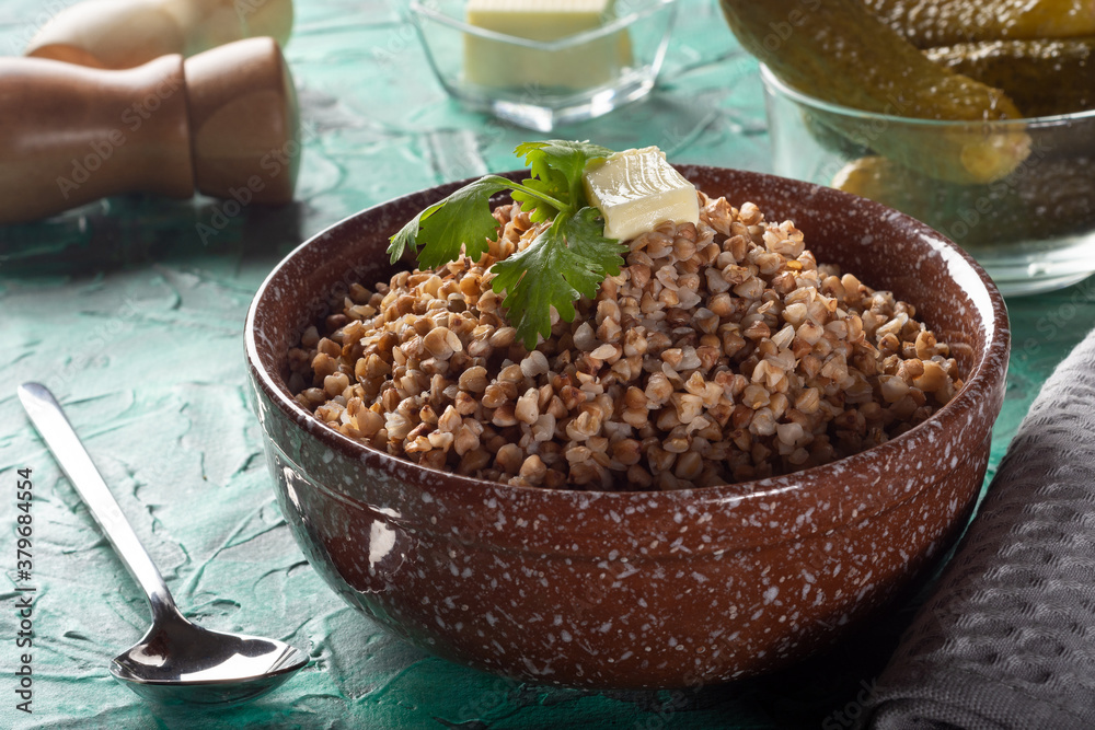 Boiled buckwheat with butter. Ready-made buckwheat in a deep dish on the table. Buckwheat with pickles. Boiled buckwheat with butter. Ready-made buckwheat in a deep dish on the table. Buckwheat with pickles.