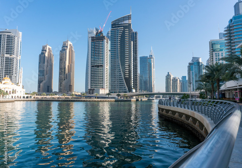 Jacht and Skyscrapers Above the Water of Persian Gulf in Dubai Marina District in UAE photo