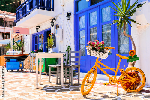 Greece street taverns decorated with flowers and old bicycle.