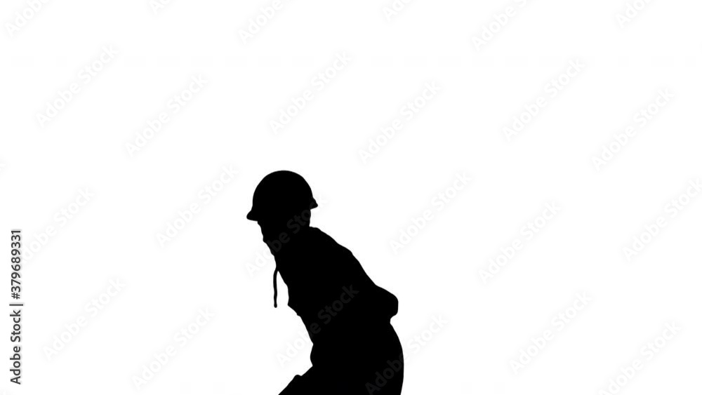 Silhouette Young construction worker in yellow hardhat break dancing looking at camera. Silhouette Young construction worker in yellow hardhat break dancing looking at camera.