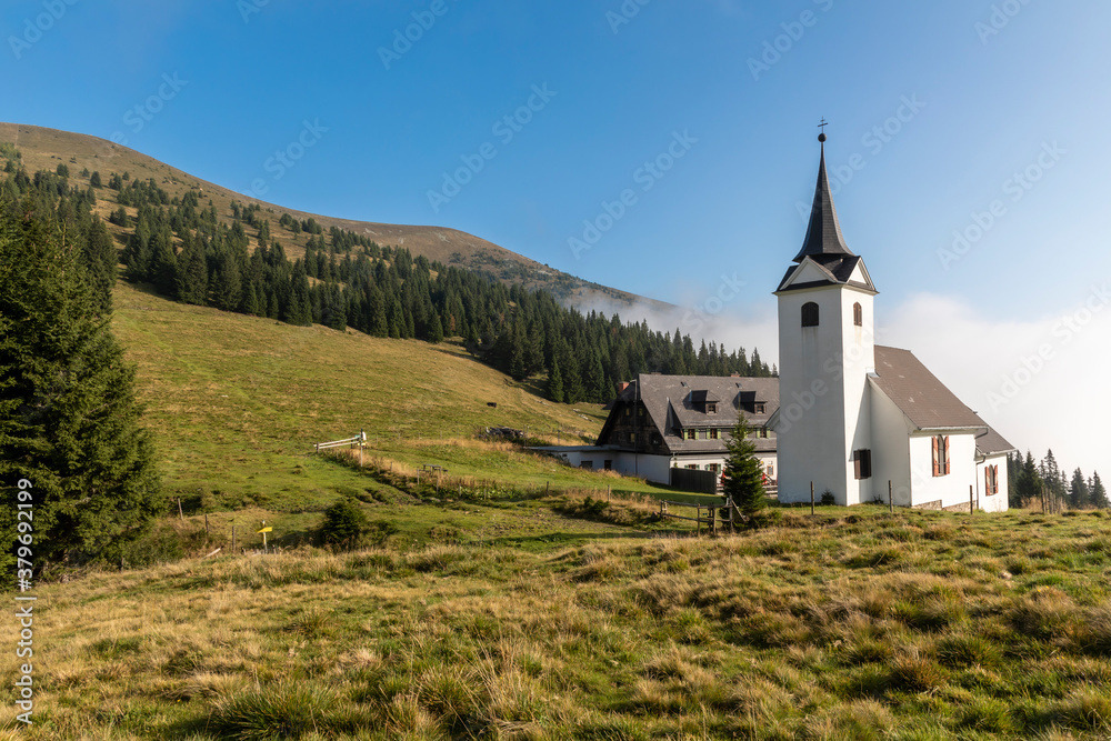 mountain range Gleinalm or Gleinalpe with summit Speikkogel and mountain hut named Gleinalmschutzhaus with chapel in the Austrian federal state of Styria