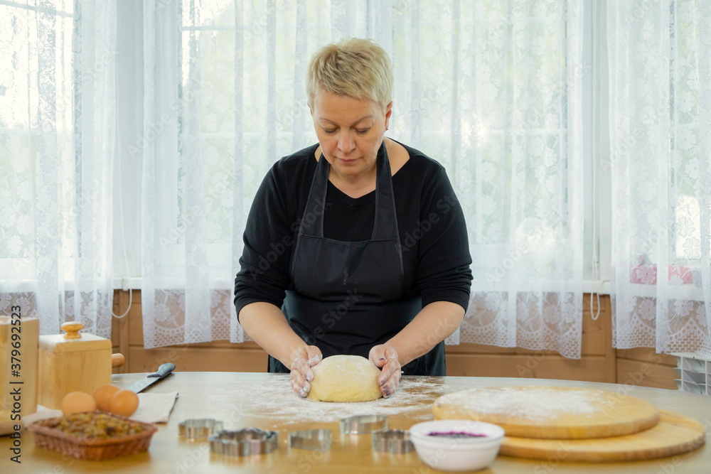 Caucasian beautyful woman housewife kneading dough on wooden antique table. Concept of home baking. Forming dough on table hands. Quarantine time. Caucasian beautyful woman housewife kneading dough on wooden antique table. Concept of home baking. Forming dough on table hands. Quarantine time.