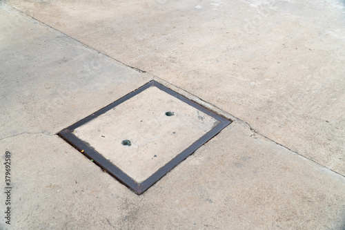 Manhole cover on concrete street.