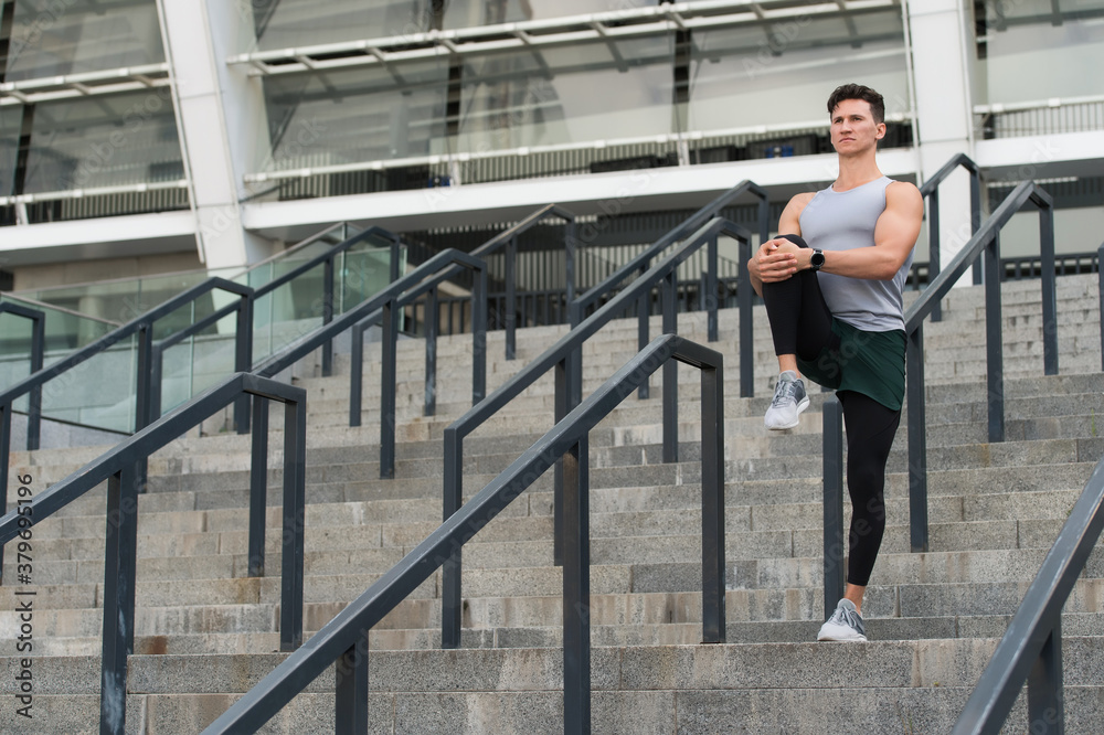 Safety of joints, guy warming up before workout urban background Safety of joints, guy warming up before workout urban background