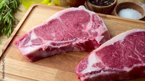raw steak meat on cutting board in bright kitchen