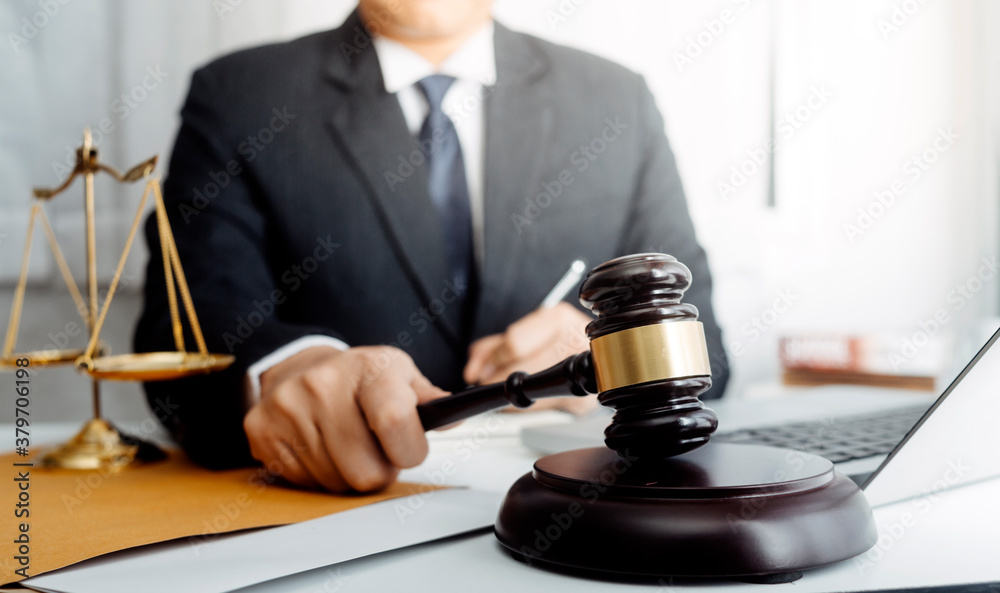 Business and lawyers discussing contract papers with brass scale on desk in office. Law, legal services, advice, justice and law concept picture with film grain effect Business and lawyers discussing contract papers with brass scale on desk in office. Law, legal services, advice, justice and law concept picture with film grain effect