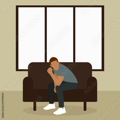 A man sits on a sofa by the window