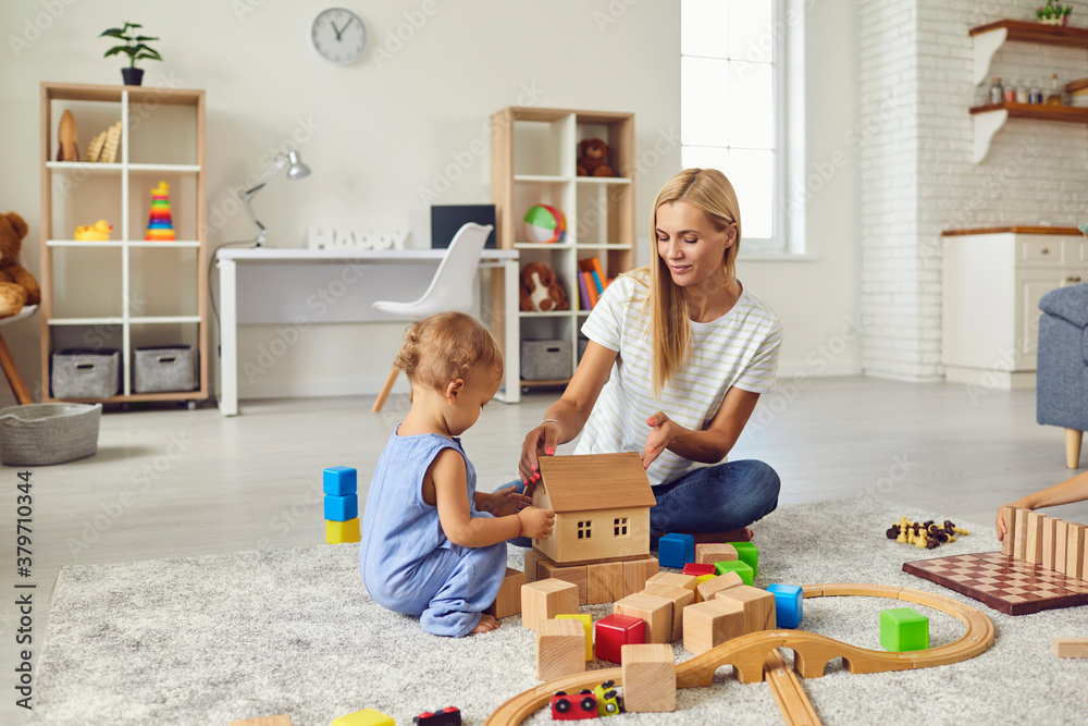Ταπετσαρία Young mom playing with cute little son and teaching him to build toy house in co