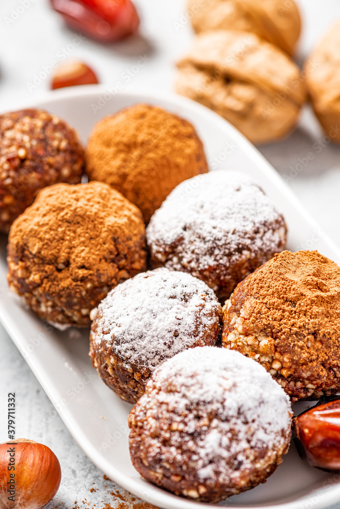 Healthy homemade paleo chocolate energy balls with nuts, dates and cocoa close-up. Homemade chocolate round candies. Sweet food with nuts.