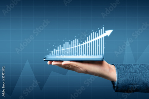 Person holding a tablet with a graph of business growth and profit
