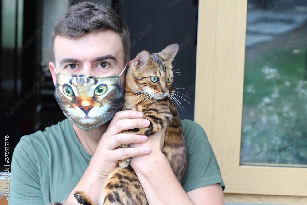 Man wearing protective mask with print of his cat´s face 
