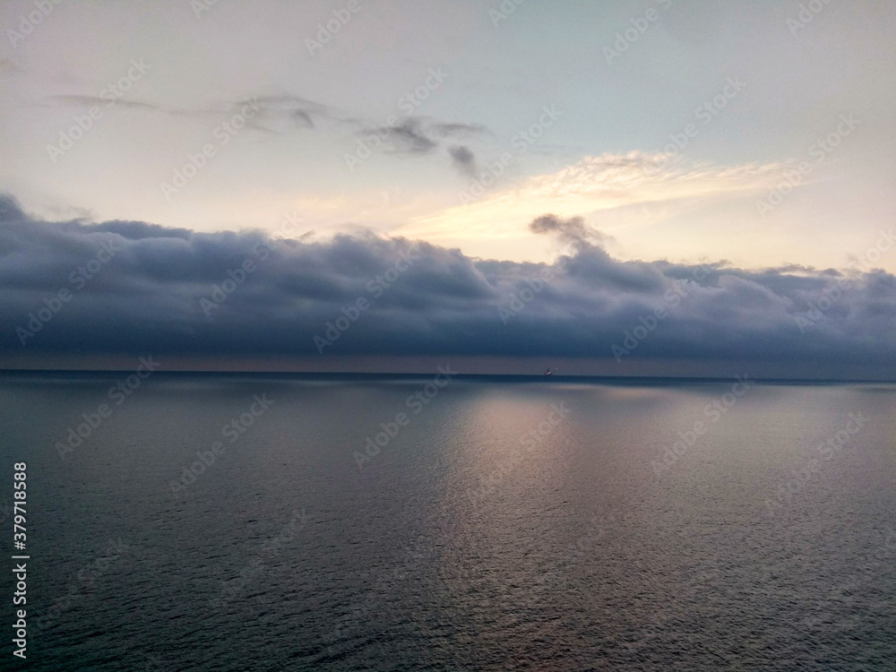 Fototapeta premium cloudy sunrise in the middle of the sea