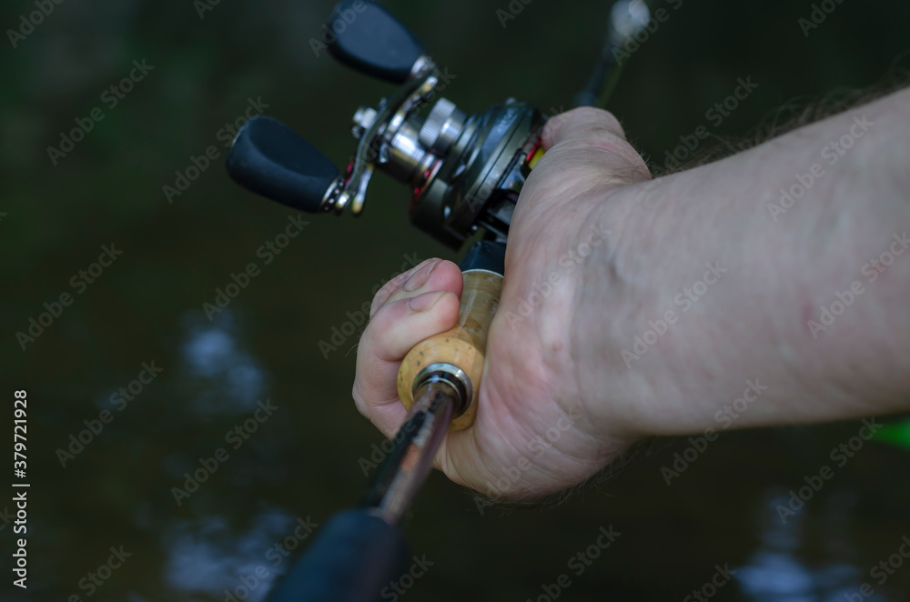 Close-up of a man's hand with bait casting rods. Stock Photo