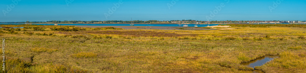 A panorama view from the East Mersea flats across the Colne River towards Brightlingsea, UK in the summertime