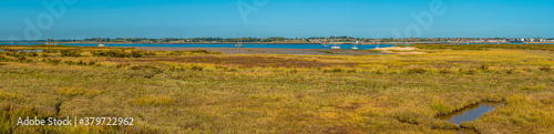 A panorama view from the East Mersea flats across the Colne River towards Brightlingsea, UK in the summertime photo