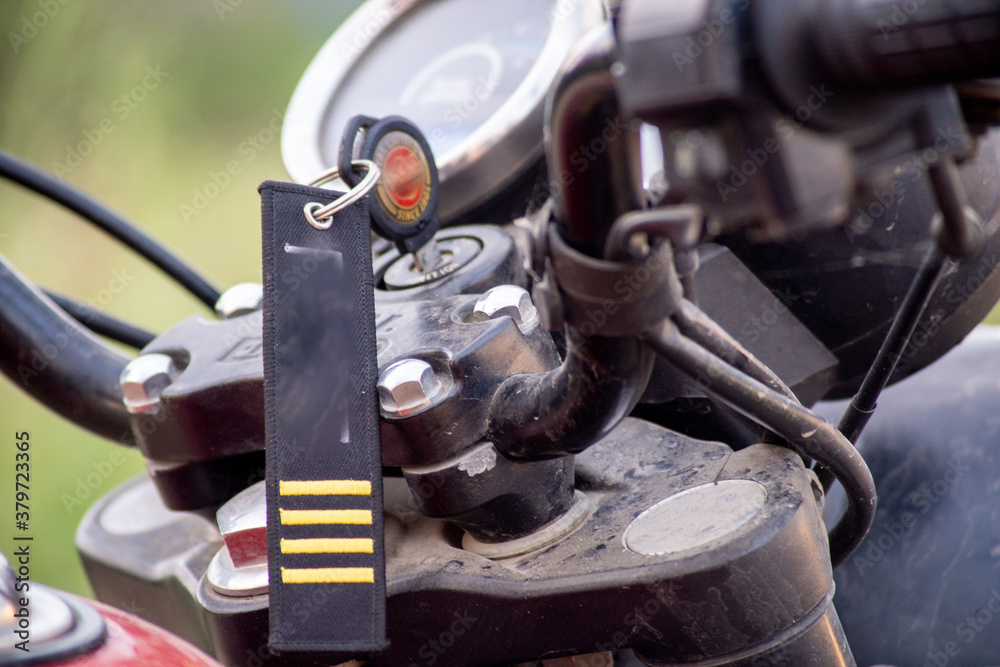 Macro shot showing the key, key fob chain, handlebar, speed dials and more. Shot closely it shows the beautiful and intricate detail in setting off on a road trip with a motorcycle bike at hand