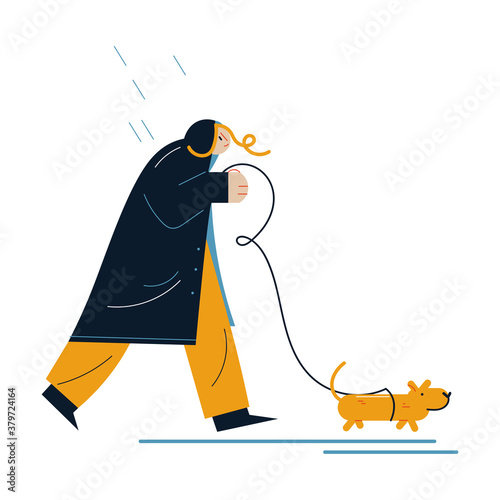 Woman in raincoat walking dog during rain in autumn