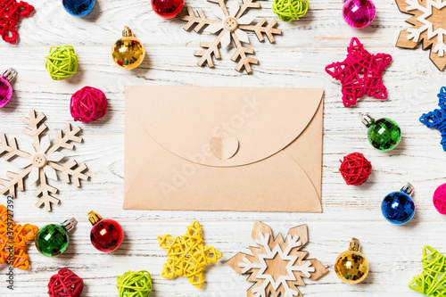 Top view of envelope on festive wooden background. Christmas toys and decorations. New Year time concept