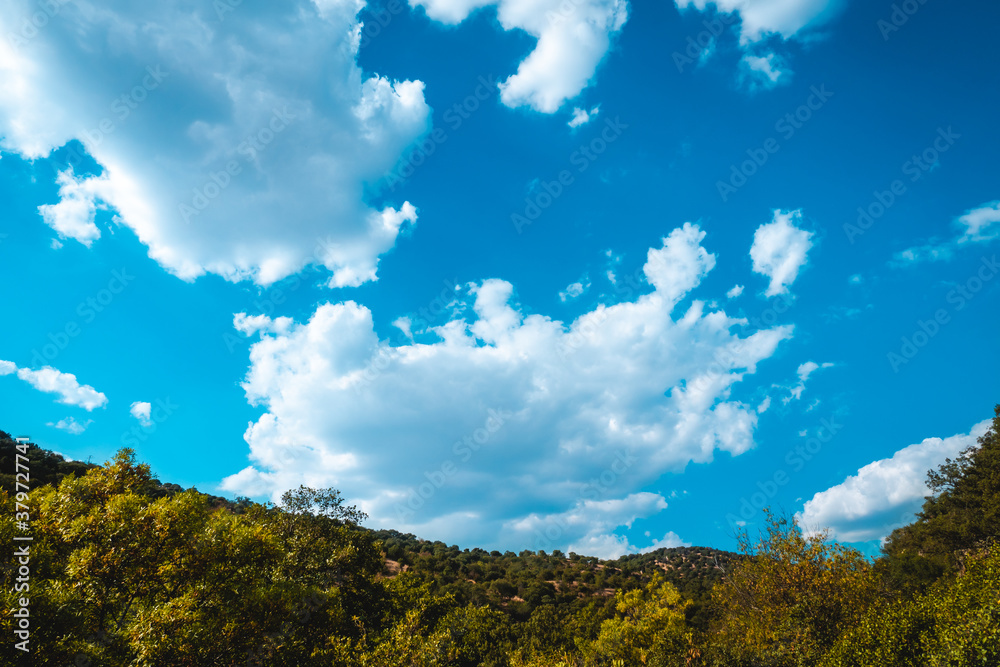 Blue sky with clouds over the mountain with green forest on a sunny day. Blue sky with clouds over the mountain with green forest on a sunny day.