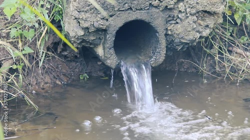 Drain pipe under road. Stream flows under road through a pipe.
 photo