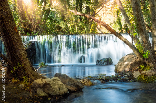 Natural waterfall called    Cascada del Hervidero    in Madrid  in the forest  with sunlight between vegetation and rocks. 