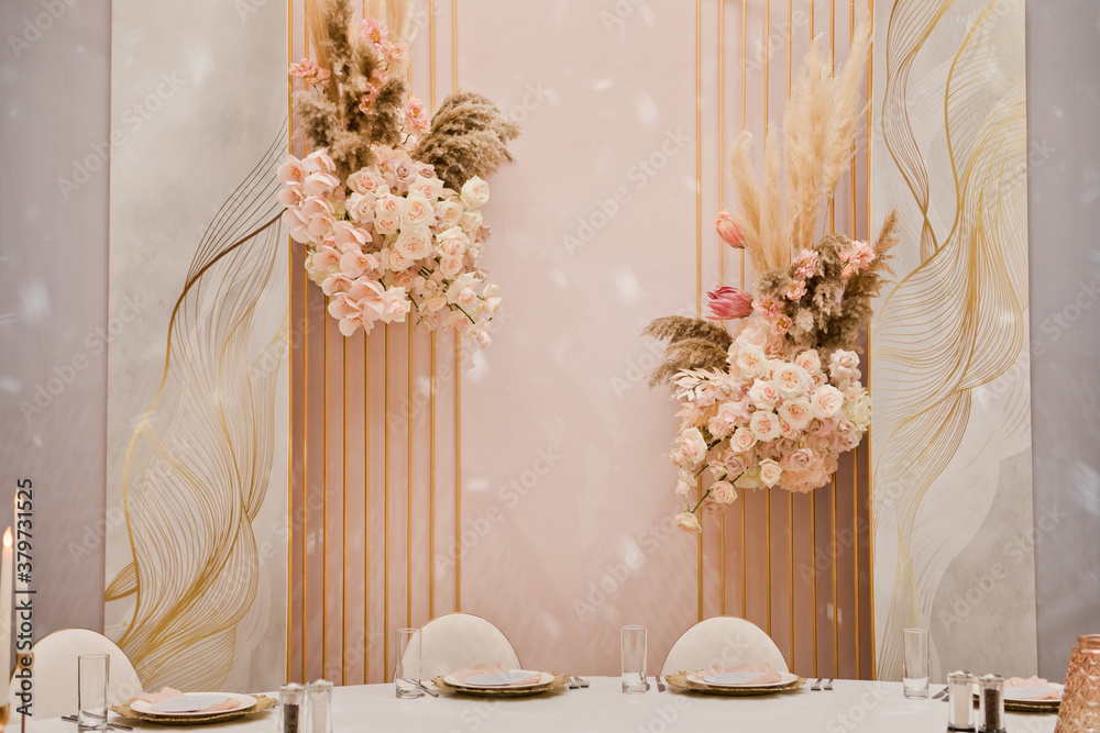 Close up of centerpiece at wedding reception. wedding decor, flowers, pink and gold decor, candles. Festive table decor.