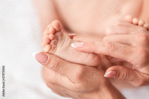 Mother hand massaging leg and foot muscle of her baby, touch of happiness, health care concept