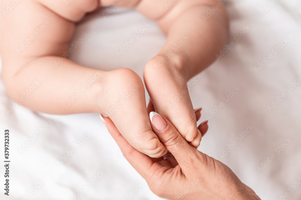 Masseur massaging little baby's foot. Mother massaging her child's foot, Foot massage for baby Masseur massaging little baby's foot. Mother massaging her child's foot, Foot massage for baby