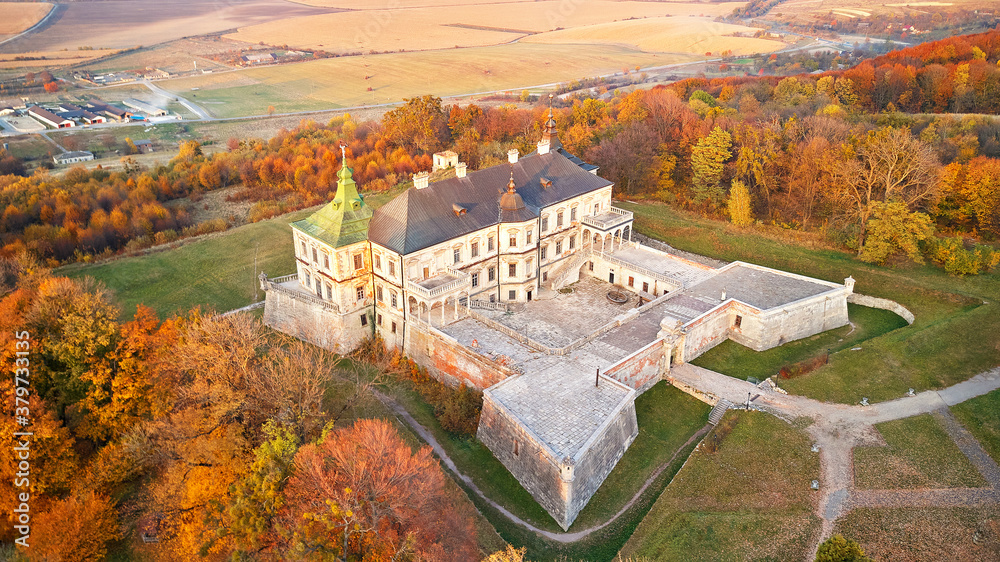 Podgortsy Palace from the air. Sunset over autumn park on hills.