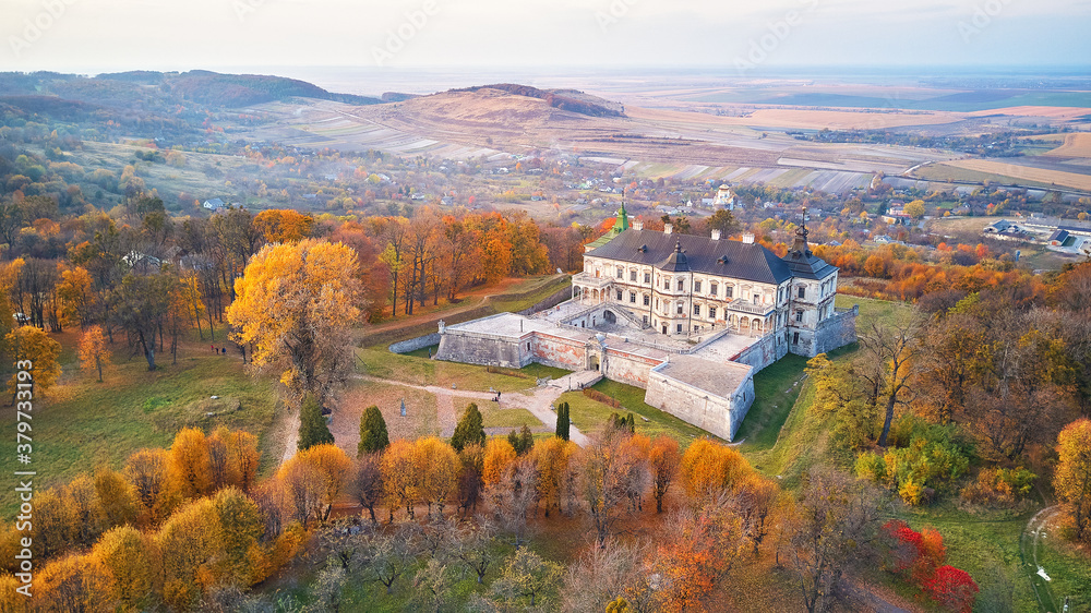 Podgortsy Palace from the air. Sunset over autumn park on hills. Aerial view of Pidhirtsi Castle