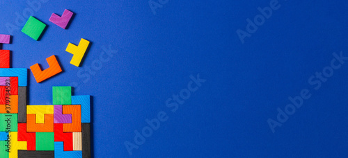 Foto Different colorful shapes wooden puzzle blocks on blue background