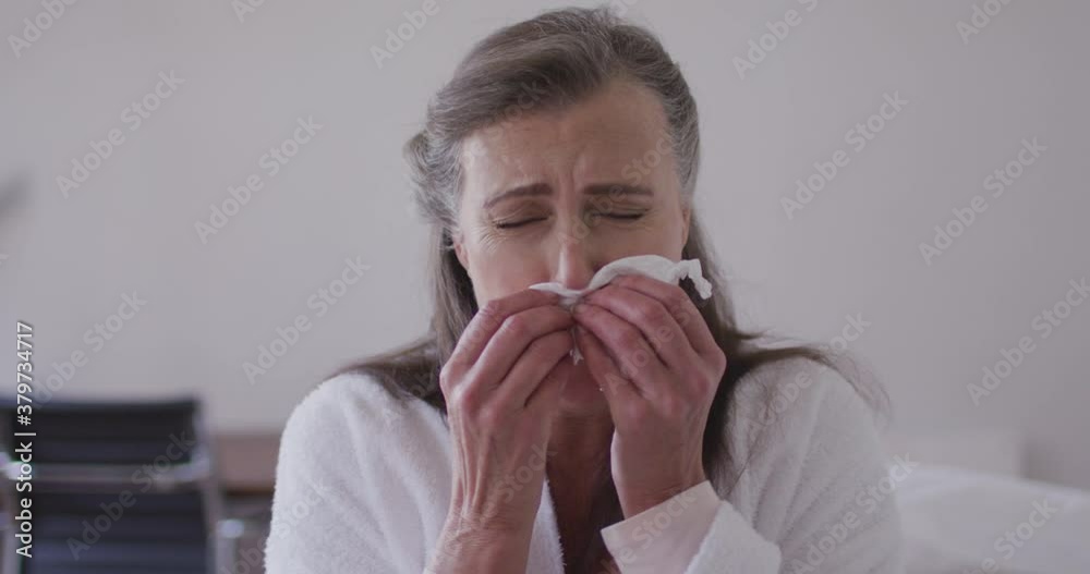 Sick woman with tissue sneezing at home Sick woman with tissue sneezing at home