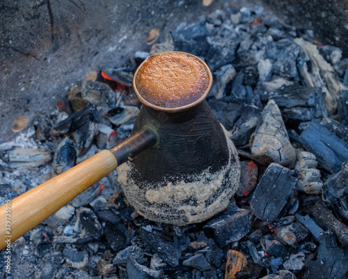 Making coffee on coals, a Turk with coffee is on top of an appetizing foam. Close-up, lots of details.
