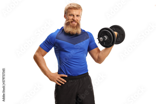 Young man with beard and moustache exercising with dumbbell in one hand