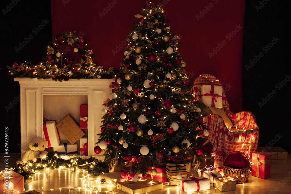 Christmas tree with gifts of garland lights for the new year in the interior of the night room as a red background