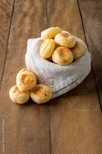Traditional Brazilian Snack Cheese Bread in a pot. On a wooden table background. copy space